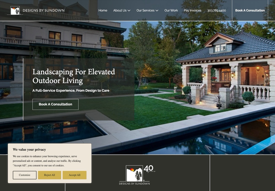 Designs by Sundown homepage with a mansion and pool photograph, a Book a Consultation button and a cookie consent dialog